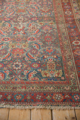 Worn ivory fringe and patterned cherry red border of an antique Malayer rug.