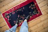 Chinese Art Deco runner's navy blue field with floral sprays and red geometric border.