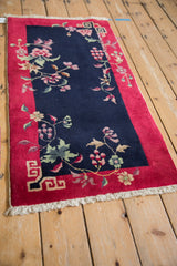 Vintage Chinese Art Deco rug corner: red border, beige key fret, navy floral field.