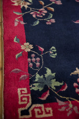 Red geometric border with navy blue field, delicate floral vinery and blossoms.
