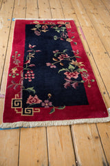 Nichols Art Deco runner: navy field, red border, floral sprays, geometric corner design.