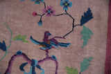 Pictorial Art Deco rug detail showing a perched bird with purple and blue plumage on a scrolling branch.