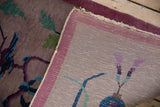 Hand-knotted back of Vintage Nichols Art Deco rug, revealing muted pictorial motifs and tattered edge.