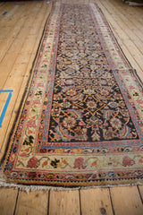 Long profile of a vintage Mahal runner with a charcoal Herati field and meandering vine border.