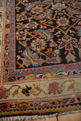 Corner detail of a vintage Mahal rug, showing the vine and boteh borders and low pile texture.