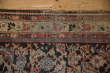 Tattered end of a vintage Persian Mahal runner showing worn pile and exposed foundation.