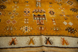 Geometric blossoms and ivory border detail on a saffron yellow vintage Moroccan rug.