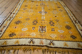 Vintage Moroccan rug, saffron yellow pile, ivory geometric border, brown blossoms and fringe.