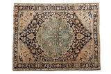 Vintage distressed Persian Malayer rug with jade green medallion and navy blue field.