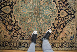 Distressed vintage Malayer rug, with central medallion, navy, teal, and antique ivory patterns.