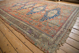 Antique Caucasian Soumac carpet showcasing brick red, sapphire blue medallions, geometric plants, and animal motifs.