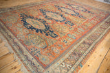 Antique Caucasian Soumac field with sapphire blue gul medallions, woven figures, and rich abrashes.