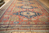 Brick red Caucasian Soumac border detail with wave motif, geometric blossoms, and textured fringe.