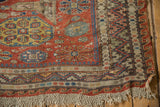 Antique Caucasian Soumac carpet bottom corner, brick red wave motif, and macrame fringe.