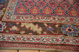 Serrated leaf and palmette border on antique Kurdish rug in cherry red, blue, and saffron.