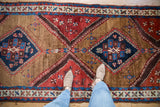 Antique Azeri runner's sapphire blue, camel, and brick red geometric patterns.