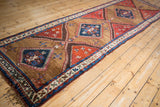Fringed end of antique Azeri rug runner, displaying geometric borders and sapphire blue medallion.