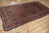Fringed corner of the antique Northwest Persian rug, featuring intricate wine red and dusty fuchsia border details.