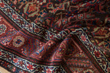 Hand-knotted Herati motif and geometric border details in chocolate, wine, and sapphire.
