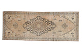 Distressed vintage Senneh Baft runner: antique ivory field, dark charcoal medallion, and vinery.