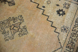 Distressed vintage Senneh Baft rug detail: soft antique ivory pile, charcoal geometric patterns.