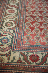Close-up of the hand-knotted boteh pattern and floral border on a vintage Persian runner.