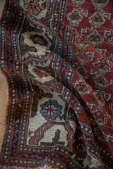 Detailed view of the short wool pile and boteh pattern on a vintage Hamadan runner rug.