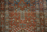 Low pile texture of a vintage Karaja rug showing hook-and-latch and plant motifs in rust and dusty blue.
