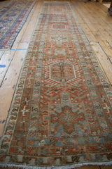 A distressed Persian Karaja runner viewed from one end showing its column of geometric medallions.