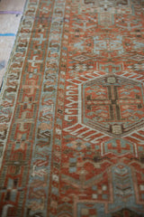 Angled view of the distressed pile on a vintage Karaja runner with rust and blue geometric motifs.