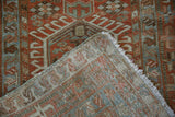 Folded corner of a vintage Karaja runner revealing its hand-knotted back and wool pile.