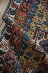 A folded vintage Karaja runner showing the low pile texture and geometric patterns in blue and red.