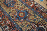 Angled close-up of a vintage Karaja runner's low pile and geometric hook motifs.