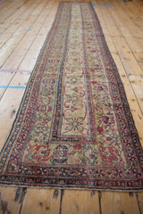 Close-up of antique Kermanshah runner with repeating pinwheel floral vinery and even wear.