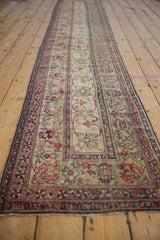 Reconditioned antique Kermanshah fragment runner in ivory, navy, red curvilinear floral vinery, even wear.