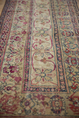 Antique Kermanshah runner close-up: ivory pinwheel florals, cochineal red scrolled vinery, navy blue borders.