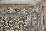 Distressed Kurdish Hamadan rug corner with chocolate brown, beige, and dusty blue plant motifs.