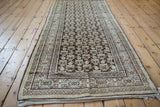 Distressed Kurdish Hamadan runner corner, revealing knot heads, beige plant motifs, and border design.