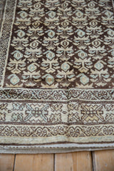 Distressed Kurdish Hamadan runner detail showing worn pile, chocolate brown, beige, and blue plant motifs.