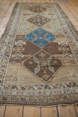 Sky blue diamond medallion with subtle plant motifs on the distressed sand field.