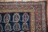 Corner of a collector Kurdish rug showing boteh motifs and complex meandering vine borders.