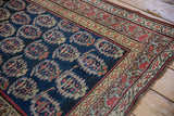 A corner view of the repeating boteh design and intricate vine borders on an antique Kurdish runner.