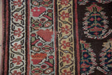 Intricate boteh motifs and meandering vine borders on an antique Kurdish collector rug.