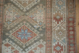 Distressed Hamadan runner displays geometric guls, starbursts, in muted blue, red, ivory tones.