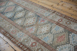 Distressed Hamadan runner: geometric diamond guls, blush vine border, and serrated floral patterns.