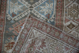 Distressed Hamadan runner detail showing geometric guls, worn pile, and hand-knotted foundation.
