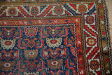 Vintage Hamadan runner close-up: Herati leaf pattern, serrated border, cobalt, cherry red.