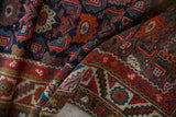 Detailed vintage Hamadan runner showing textured pile with navy, red, orange Herati leaves.