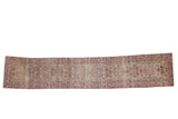 Vintage distressed Yezd rug runner with a single column of starburst medallions in dusty magenta and silver.