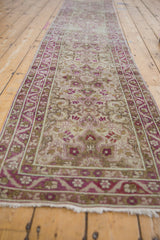 Angled perspective of a vintage distressed Yezd runner showing its length, silver field, and magenta motifs.
